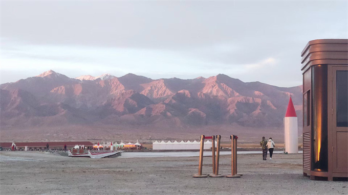 中途歇腳處，遠(yuǎn)處為戈壁和高山，夕陽(yáng)映射下，延綿不絕的高山呈火紅的獨(dú)特風(fēng)貌，甚是絕美！